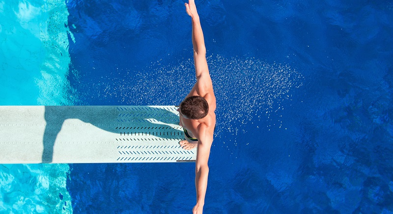 Springboard diving competitor concentrating before the dive. Shot from above, polarizing filter